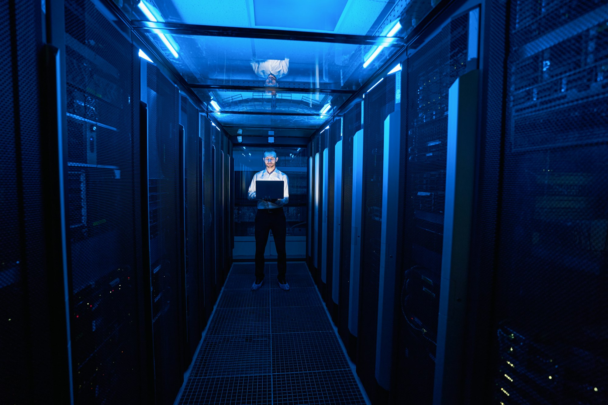 Server administrator standing in hallway of data center